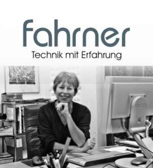 Logo mit Christine Fahrner am Schreibtisch